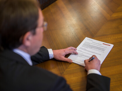 Bürgermeister unterzeichnet Antrag auf Schreibtisch. (Foto: Kalteis)