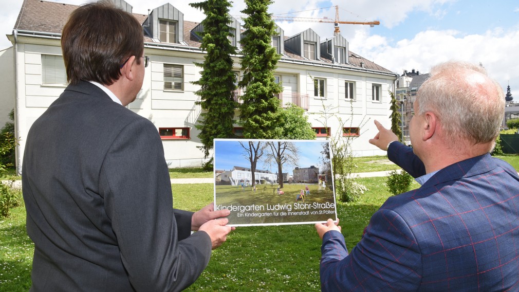 Zwei Personen mit einer Visualisierung des neuen Kindergartens. (Foto: Josef Vorlaufer)