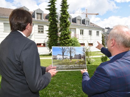 Zwei Personen mit einer Visualisierung des neuen Kindergartens. (Foto: Josef Vorlaufer)