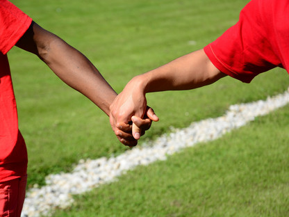 Kinder Hand in Hand am Fußballplatz. (Foto: Ulrich/pixabay)