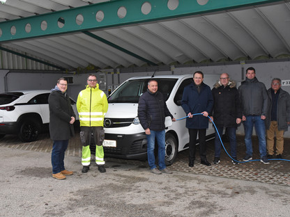 Sieben Personen posieren für ein Gruppenfoto vor einem Elektro-Auto, das an einer der neuen Ladestationen am Wirtschaftshof angesteckt ist. (Foto: Josef Vorlaufer)