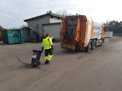 Mitarbeiter der Müllabfuhr bringt Mülltonne zu Müllentsorungs-Lastkraftwagen. (Foto: Jürgen Pomberger)