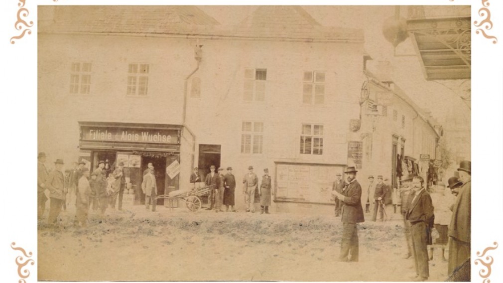 Historische Ansicht von 1884 auf die Kolonialwarenhandlung Alois Wuchse, Ecke Kremser Gasse/Brunngasse. (Grafik: G&L Werbe und Verlags GmbH)