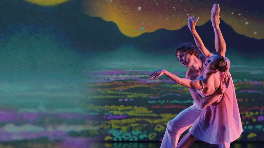Ein Tänzer und eine Tänzerin führen auf einer Bühne ein Ballettestück vor.