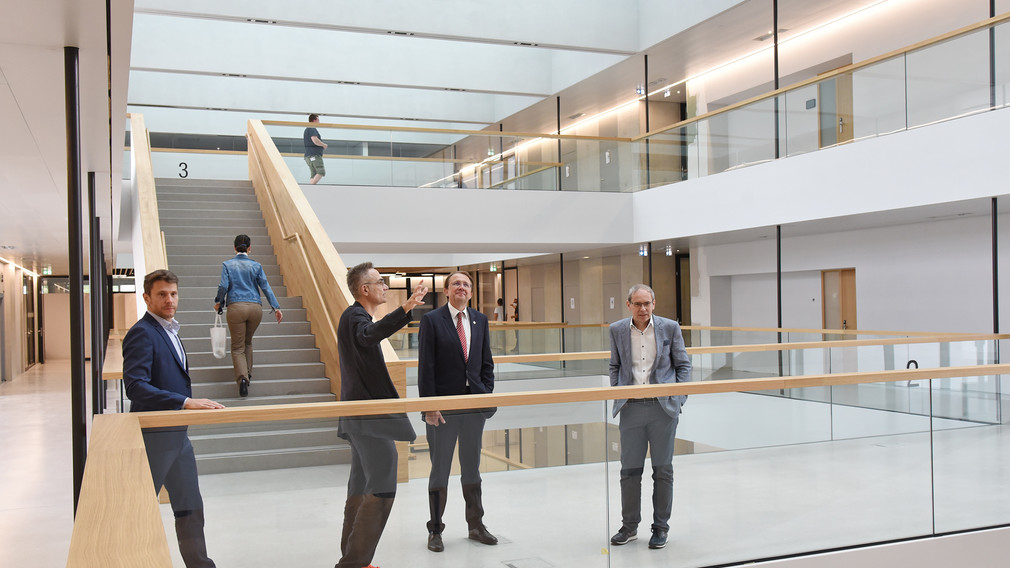 Vier Personen besichtigen den Innenraum des neuen Campus.(Foto: Josef Vorlaufer)