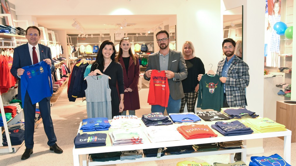 Bürgermeister Matthias Stadler und Vertreter der Stadt sowie die Betreiber des neuen Benetton-Store mit Kleidungsstücken im Geschäftslokal. (Foto: Vorlaufer)