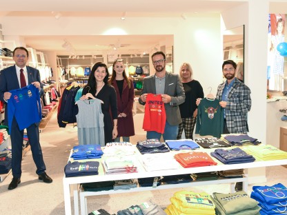 Bürgermeister Matthias Stadler und Vertreter der Stadt sowie die Betreiber des neuen Benetton-Store mit Kleidungsstücken im Geschäftslokal. (Foto: Vorlaufer)