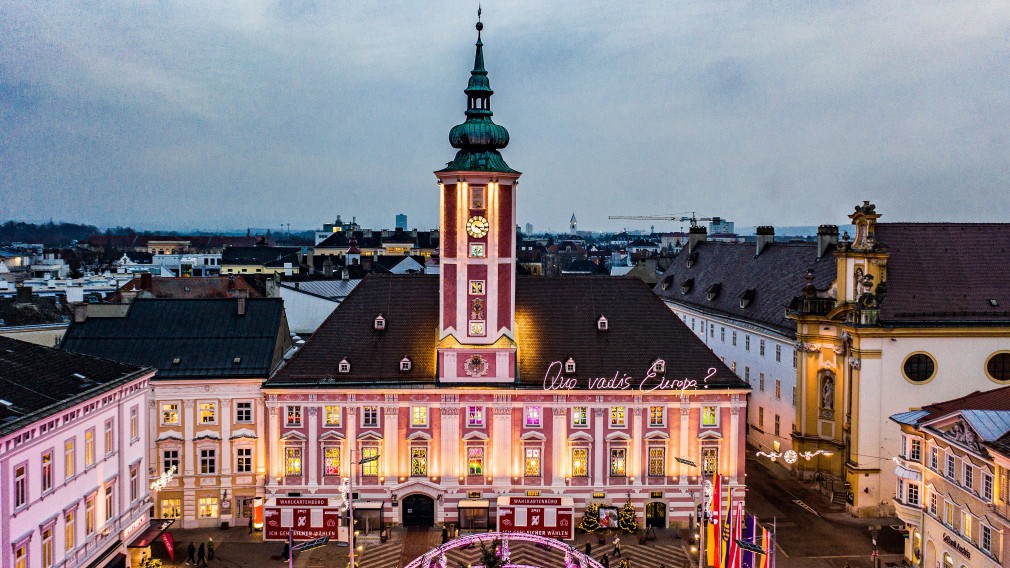 Das Rathaus und die beleuchteten Fenster mit den Bildern der Kinder. Foto: Josef Bollwein