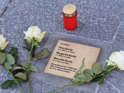 Gedenktafel mit Namen eingraviert , Kerzen und Rosen. (Foto: Josef Vorlaufer).