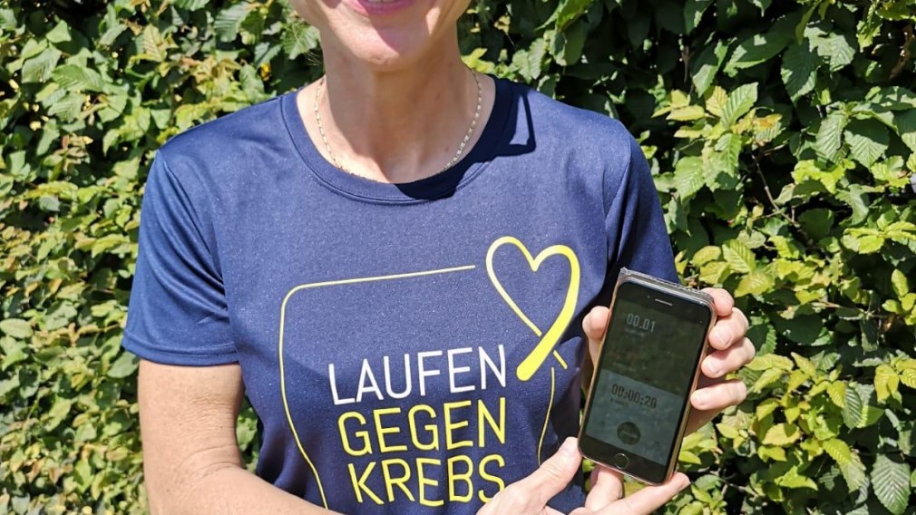 Frau mit Frauenlauf T-Shirt und Smartphone in der Hand. (Foto: Frauenlauf)