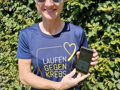 Frau mit Frauenlauf T-Shirt und Smartphone in der Hand. (Foto: Frauenlauf)