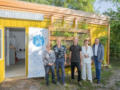 Mehrere Personen positionieren sich für ein Foto vor dem Klimaforschungslabor