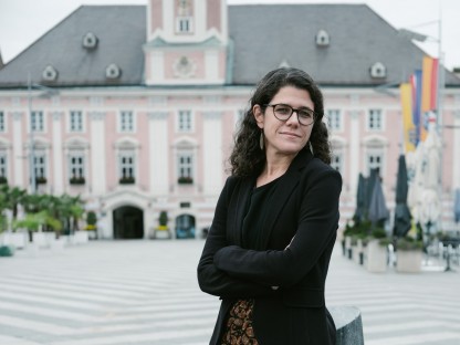 Angelika Schopper an einem Stein lehnend vor dem Rathaus