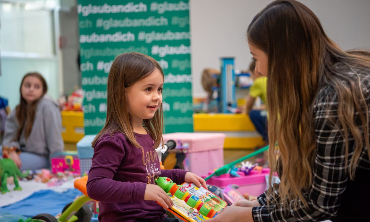 Ein Mädchen und ihre Mutter halten Spielzeug am Sparkassen-Flohmarkt in ihren Händen. Foto: Tanja Wagner
