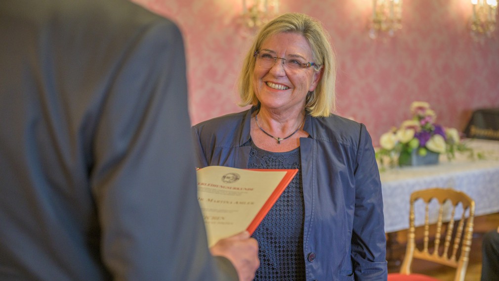 Der Bürgermeister verliest die Urkunde es Ehrenzeichens der Landeshauptstadt St. Pölten, Martina Amler ist sichtbar erfreut, ein freundliches Lächeln strahlt über ihr Gesicht.