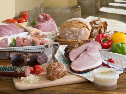 Verschiedene Wurst- und Fleischartikel, Gemüse und Aufstriche Besteck auf Holzbrett. (Foto: Werner Jäger).