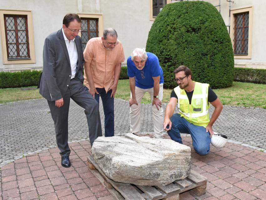 Bürgermeister Matthias Stadler, Stadtarchäologe Ronald Risy, Stadtmuseumsleiter Thomas Pulle und Archäologe Stefan Fuchs-Sommer begutachten den Stein im Museumshof. (Foto: Josef Vorlaufer)