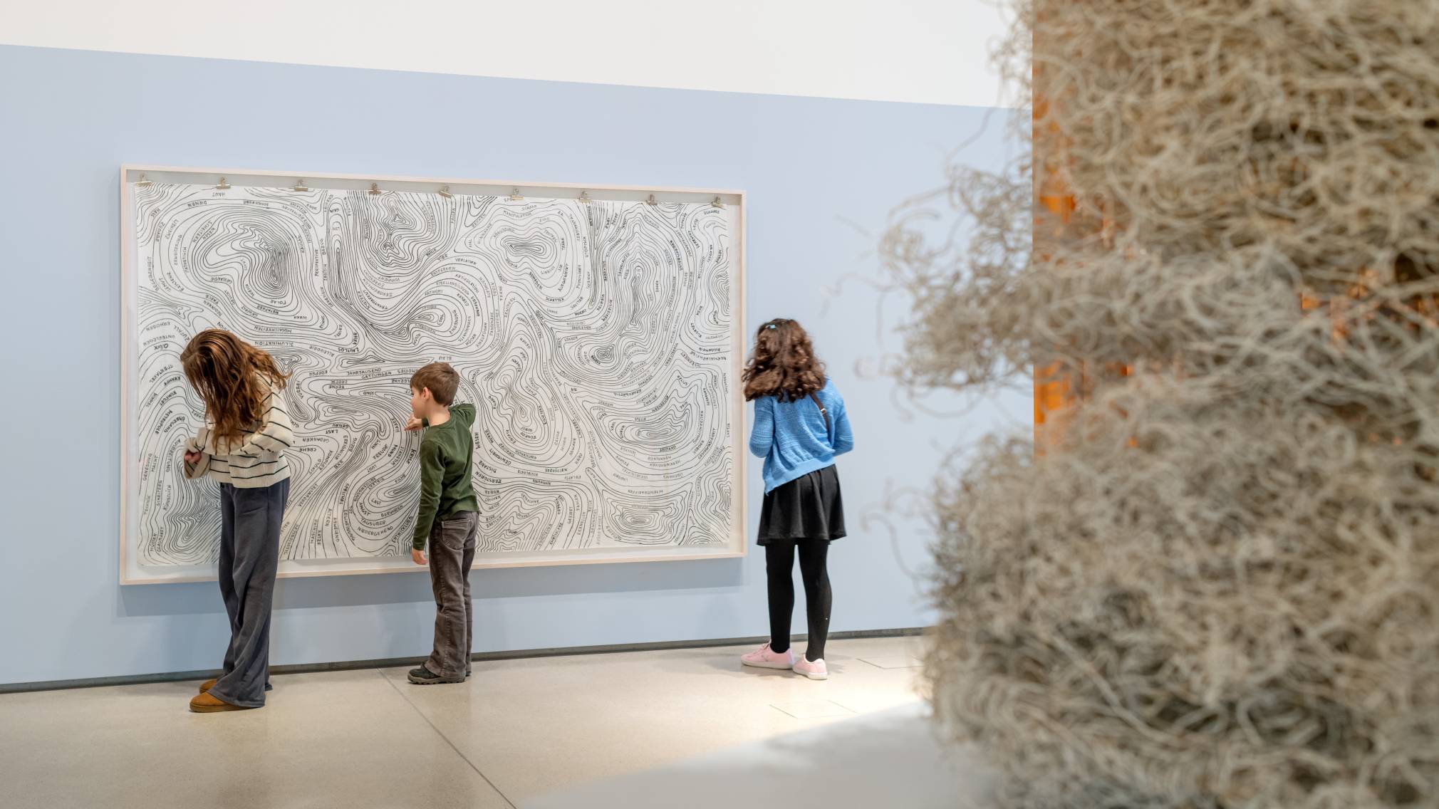 3 Kinder vor einem Bild.