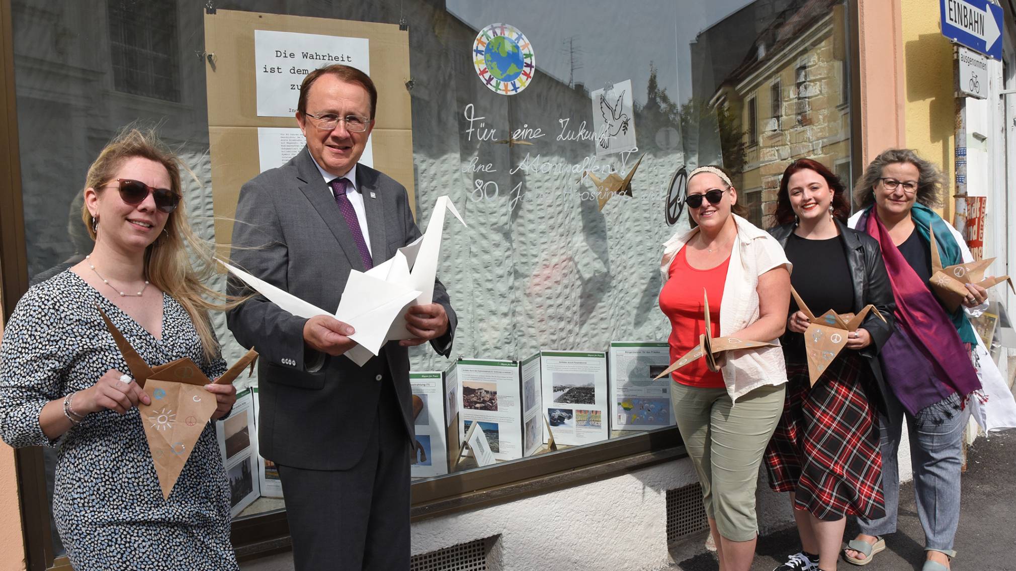 5 Personen stehen vor einer Auslage, welche die Posterausstellung zeigt. Foto: Josef Vorlaufer