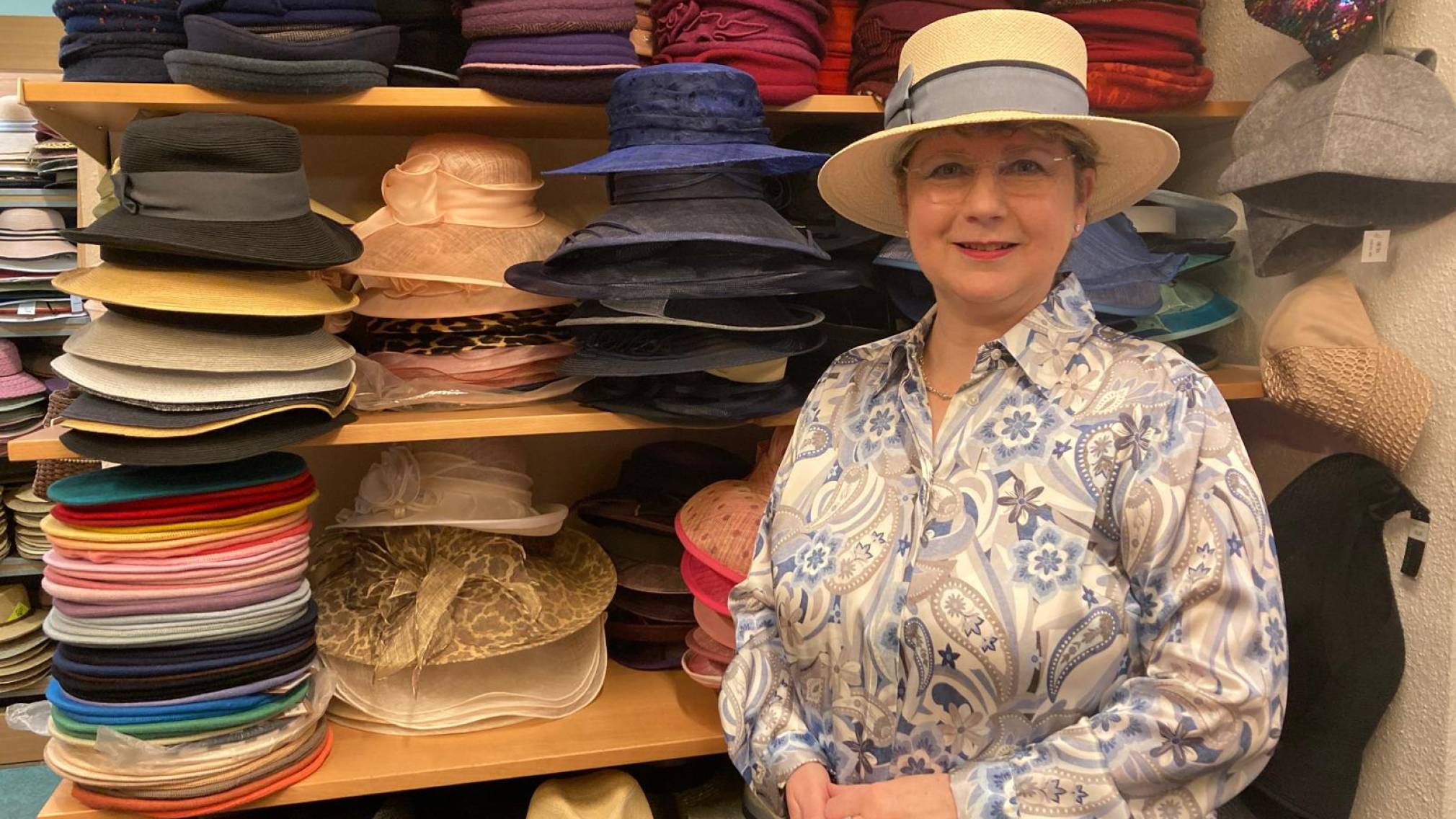 Modisten-Meisterin Anna Öckher vor Regalen voll mit bunten Hüten in ihrem St. Pöltner Geschäft. Foto: Althea Müller