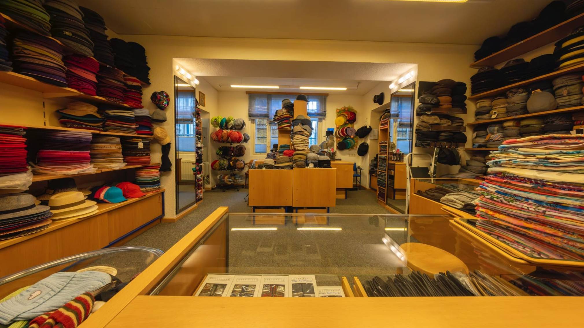 Modisten-Meisterin Anna Öckher vor Regalen voll mit bunten Hüten in ihrem St. Pöltner Geschäft. Foto: Althea Müller