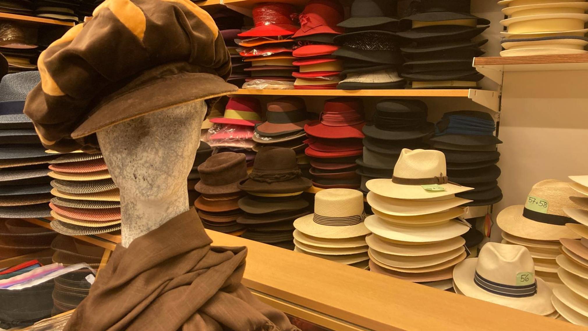 Modisten-Meisterin Anna Öckher vor Regalen voll mit bunten Hüten in ihrem St. Pöltner Geschäft. Foto: Althea Müller